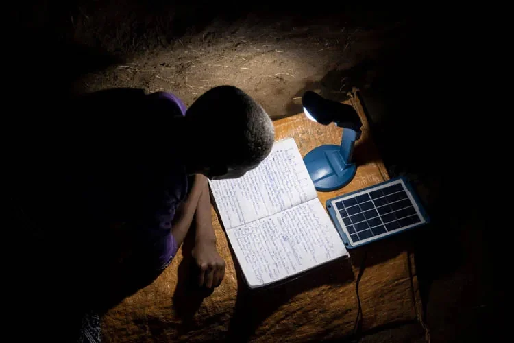 Mädchen lernt im Dunkeln mit Solarlampe | Stiftung Menschen für Menschen Kind lernt im Dunkeln mit einer Lampe