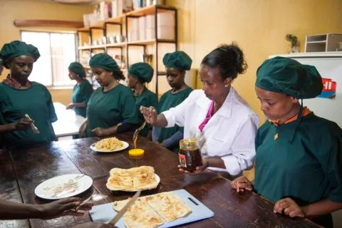 Praxisorientierte Berufsausbildung in Addis Abeba | Stiftung Menschen für Menschen Berufsschülerinnen in Hauswirtschaftsuniform folgen aufmerksam dem praxisorientierten Unterricht