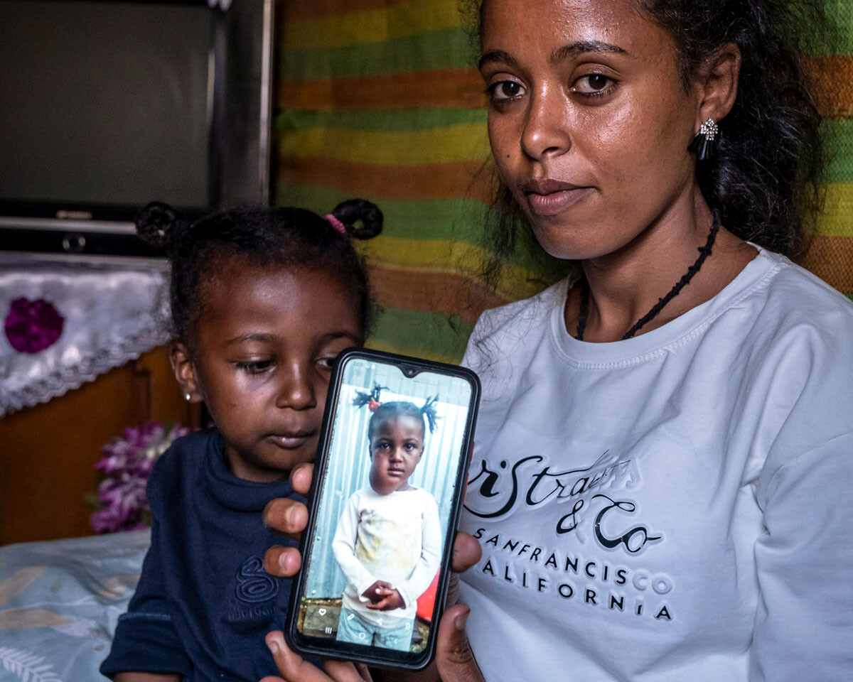 Sozialarbeiterin zeigt auf ihrem Handy ein Foto von dem Mädchen mit einem Tumor an der Wange