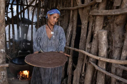 Bäuerin bäckt Injerra auf einem improved stove von Menschen für Menschen Bäuerin bäckt Injerra