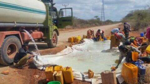 Ein Tanklastwagen verteilt Wasser an geschwächte Menschen