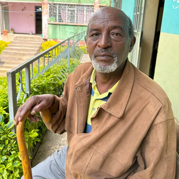 Krankenversicherung für arme Familien in Addis Abeba, finanziert von der Stiftung Menschen für Menschen, hier ein älterer Nutznießer Älterer Mann mit Gehstock in der rechten Hand