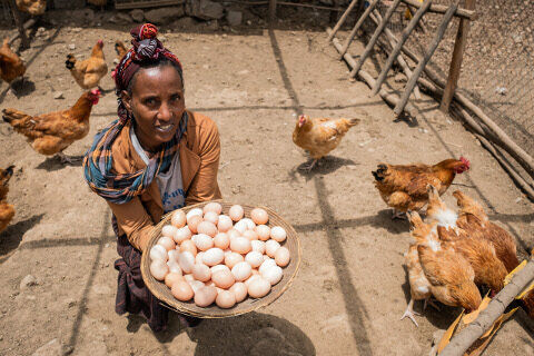 Mikrokreditnehmerin Wude mit Korb voller Eier