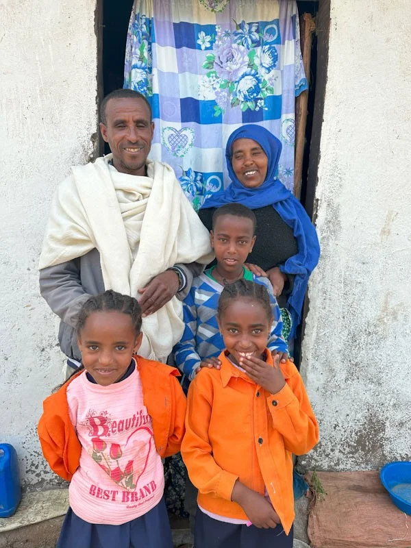 Die ganze Familie vor dem Hauseingang: Der Vater, die Mutter, der Sohn und die Zwillingsschwester