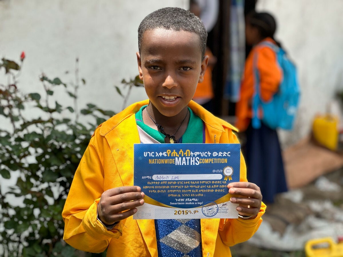 Junge zeigt stolz seine Auszeichnung für einen Mathematik-Wettbewerb