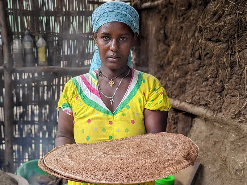 Frau hält Injerra-Fladenbrot in der Hand