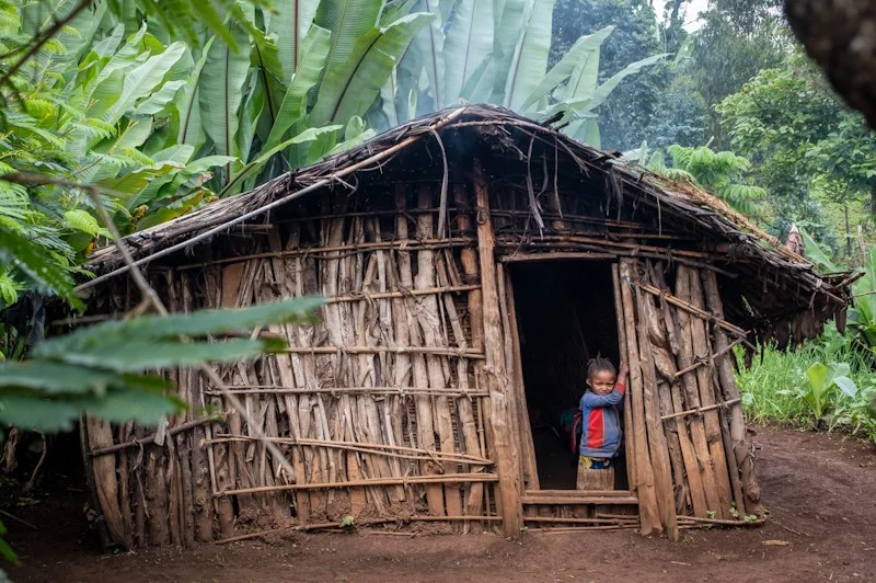 Mädchen im Eingang der Holzhütte | Stiftung Menschen für Menschen Mädchen steht im Eingang der Holzhütte