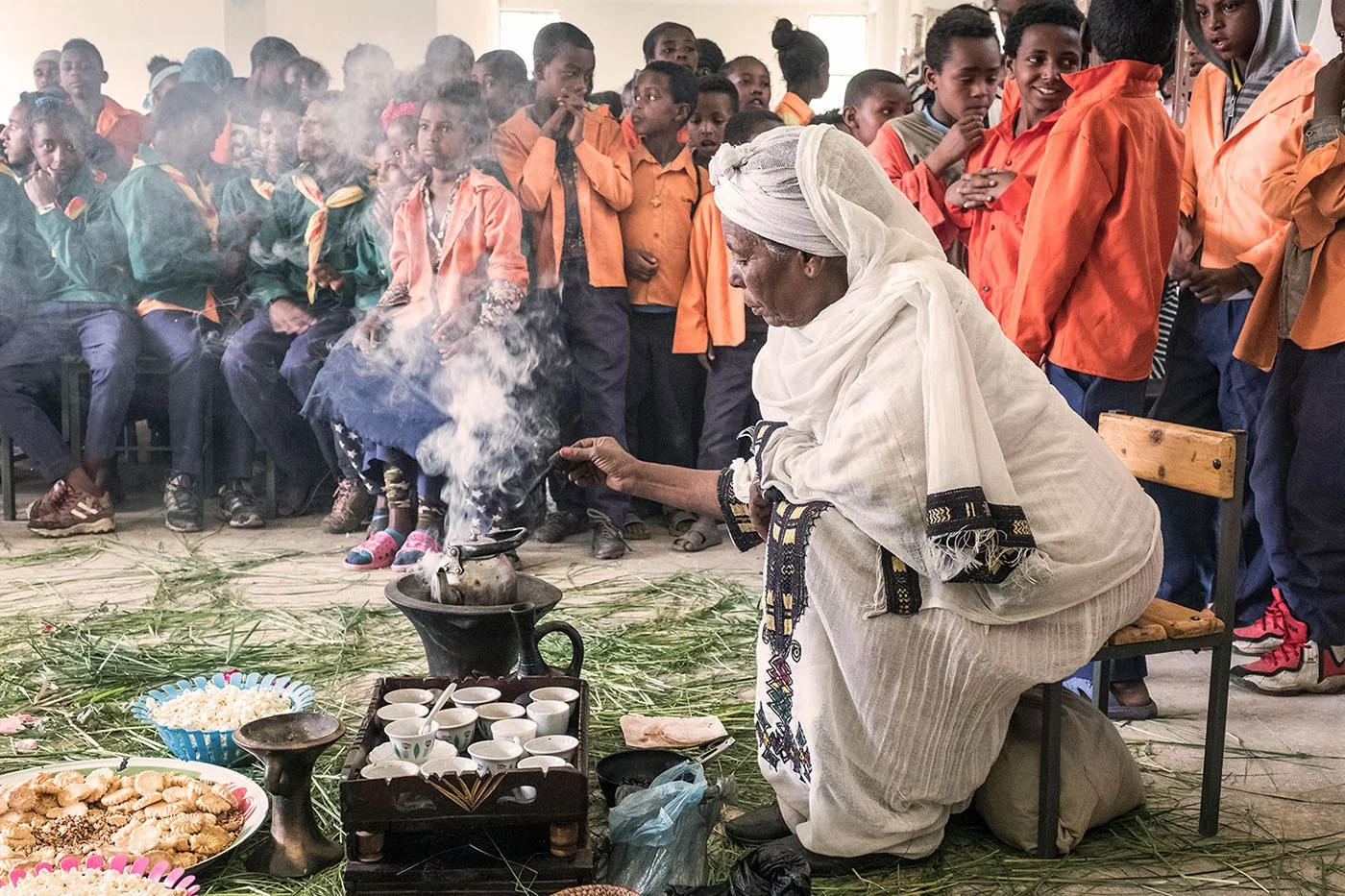 Traditionelle Kaffeezubereitung in Äthiopien | Stiftung Menschen für Menschen Frau in traditioneller, äthiopischer Kleidung röstet Kaffeebohnen vor Ort