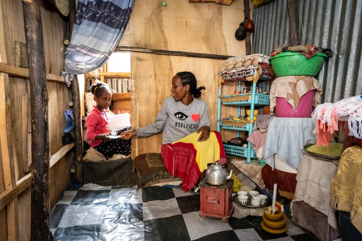 Familie in Debre Berhan,Äthiopien | Stiftung Menschen für Menschen Die Mutter reicht ihrer Tochter eine Teetasse