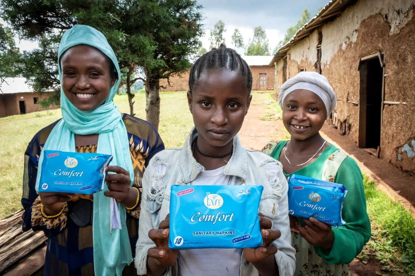 Drei Mädchen zeigen ihre Monatsbinden