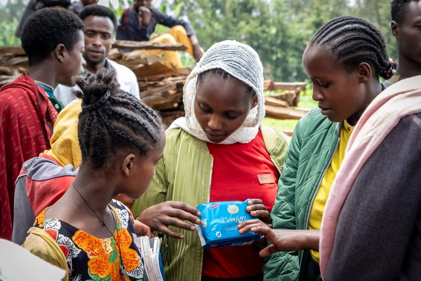 Mädchen zeigt anderen Mädchen die Monatsbinden