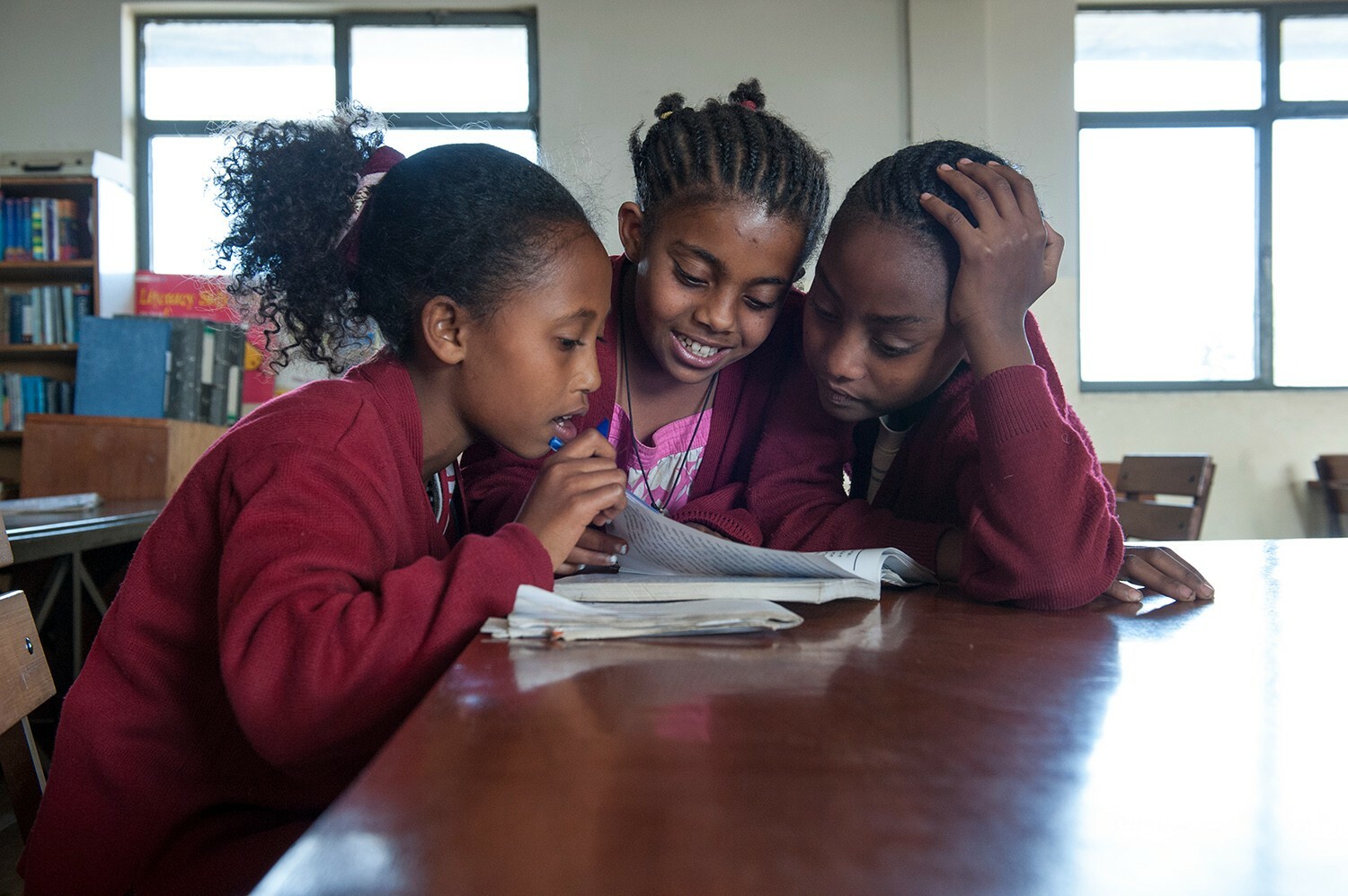Drei Mädchen lernen in der Schulbibliothek