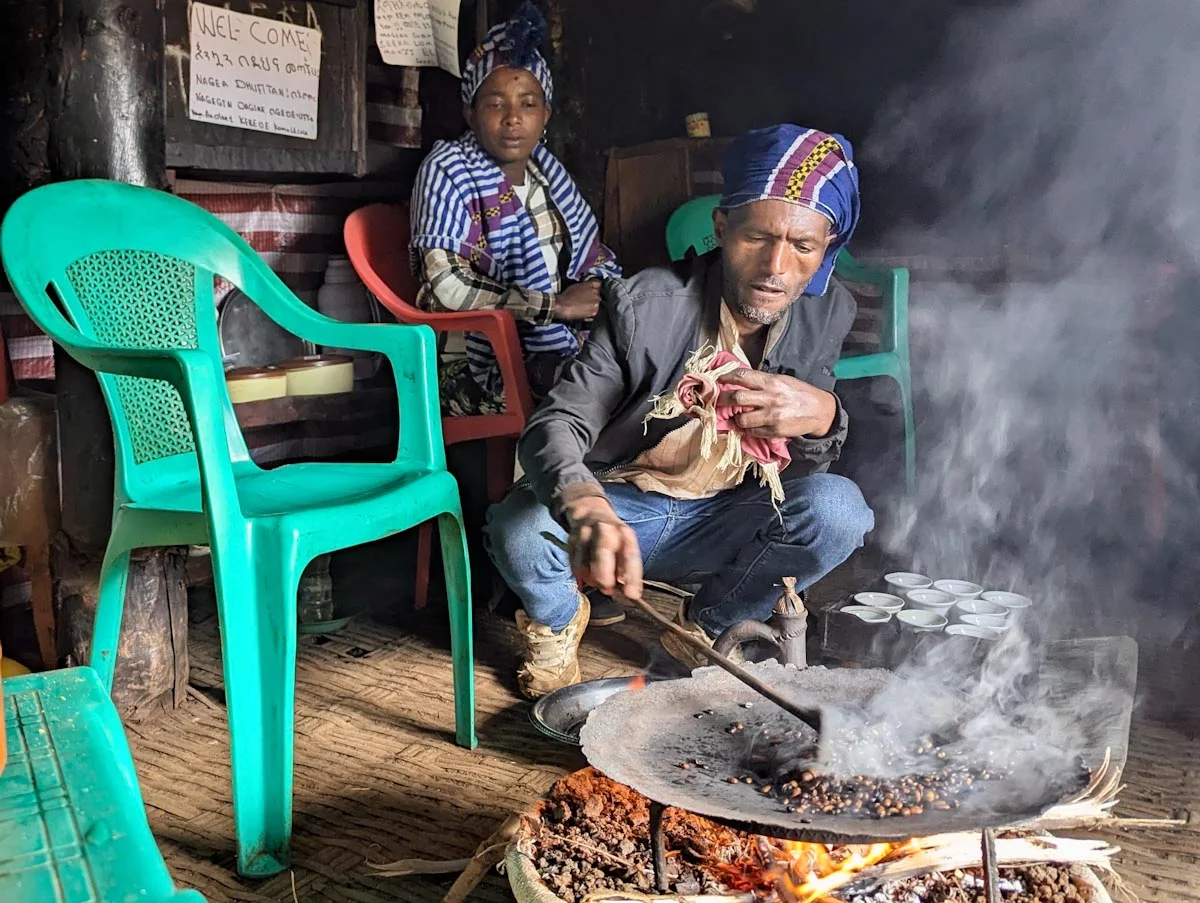 Bauer röstet Kaffee vor den Augen seiner Frau