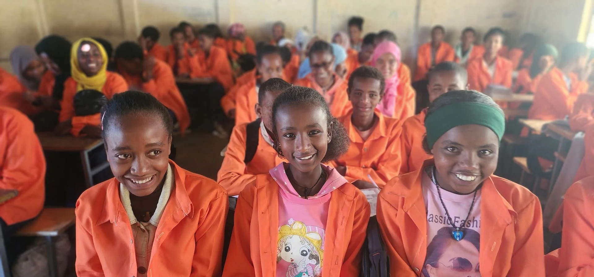 Schülerinnen in orangen Schuluniformen