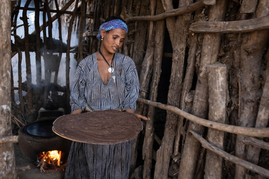 Bäuerin in Fogera backt das tägliche Injerra. Am Hals blinkt ein österreichischer Taler