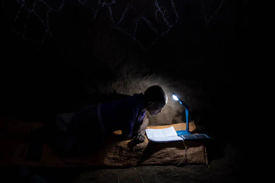 Mädchen lernt mit einer Solarlampe im Dunkeln