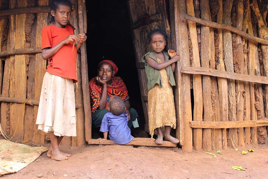 Fikre Demeke mit Kindern vor ihrem Hauseingang der traditionellen Rundhütte