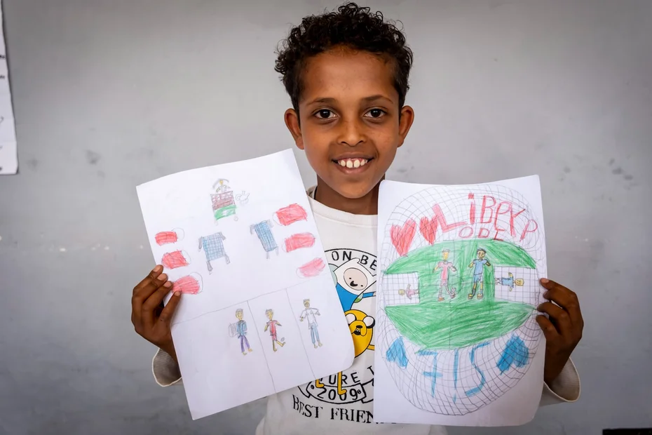 Junge zeigt stolz seine Zeichnungen