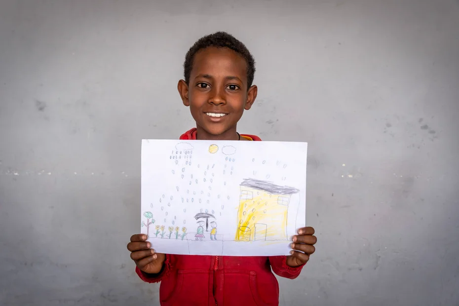 Junge zeigt stolz seine Zeichnung