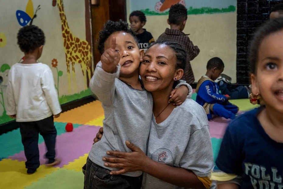 Glückliche Mutter mit ihrem Sohn in der Kinderkrippe