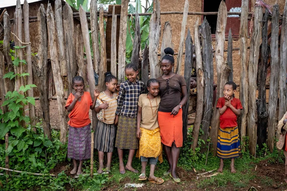 Kinder stehen vor einem Holzzaun