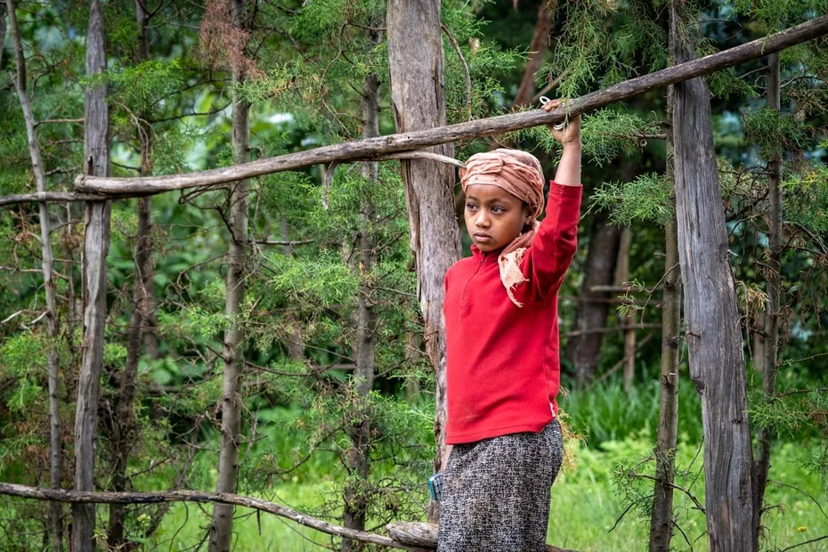 Mädchen in rotem Pullover guckt nachdenklich in die Ferne