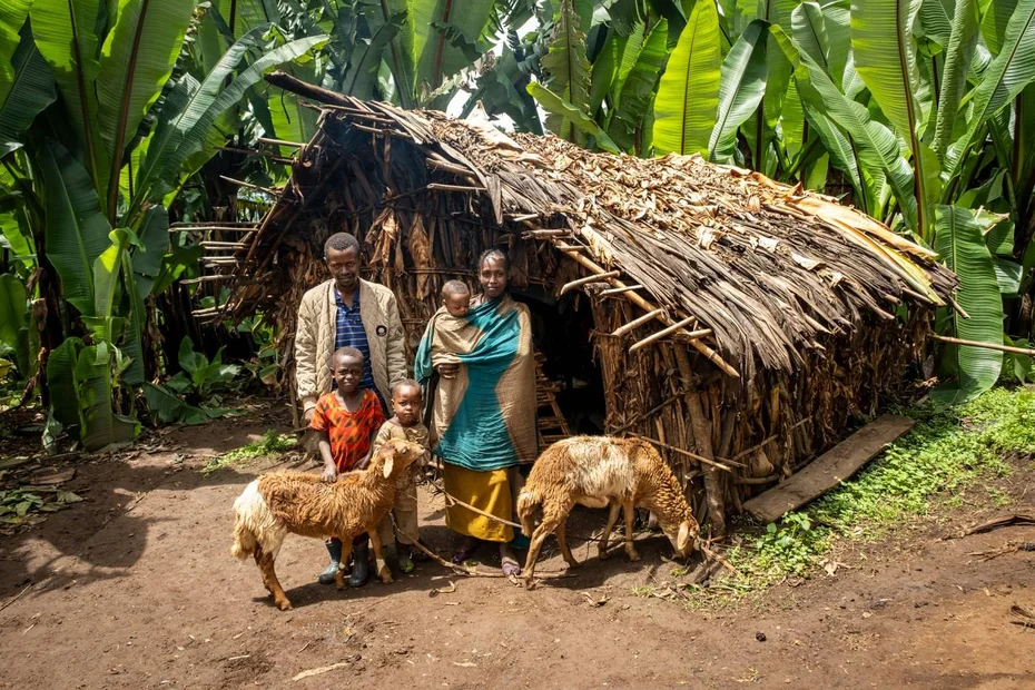 Bauernfamilie steht mit Schafen vor ihrer Hütte