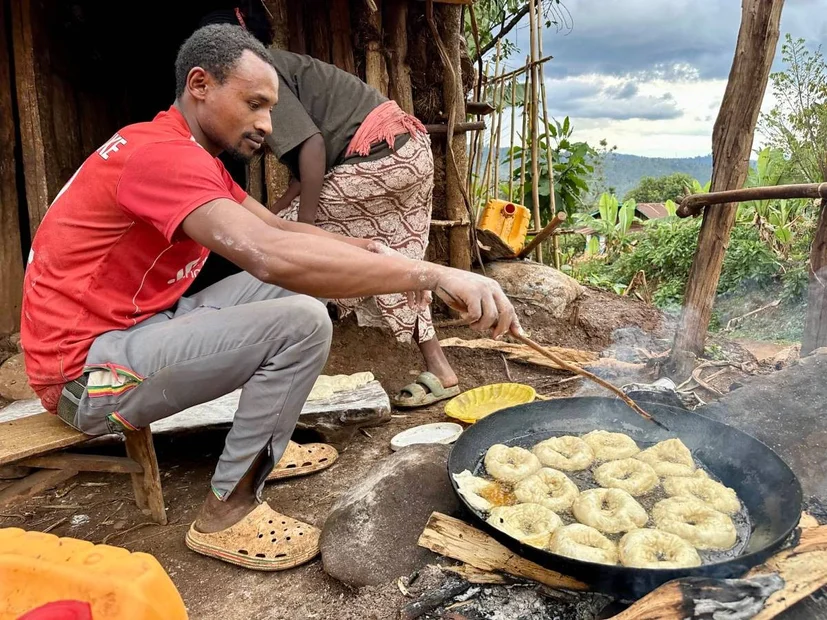 Der Ehemann frittiert Bombolinos in der PFanne