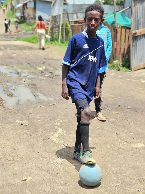 Habtamu in Fussballtrikot und Fuss auf dem Fussball