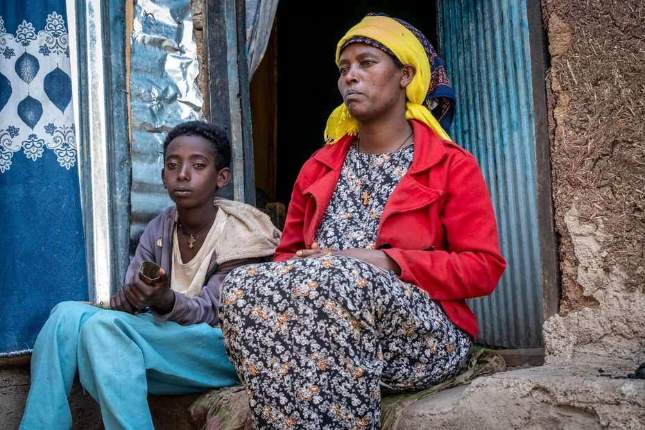 Habtamu sitzt mit seiner Mutter vor ihrer Unterkunft