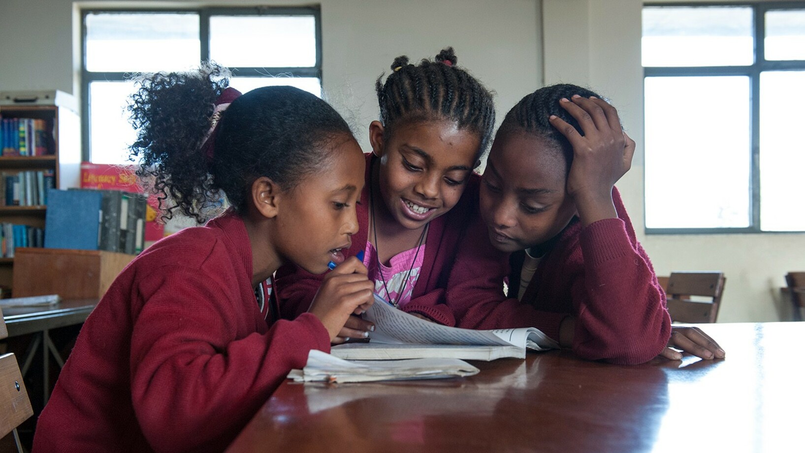 Drei Mädchen lernen in der Schulbibliothek