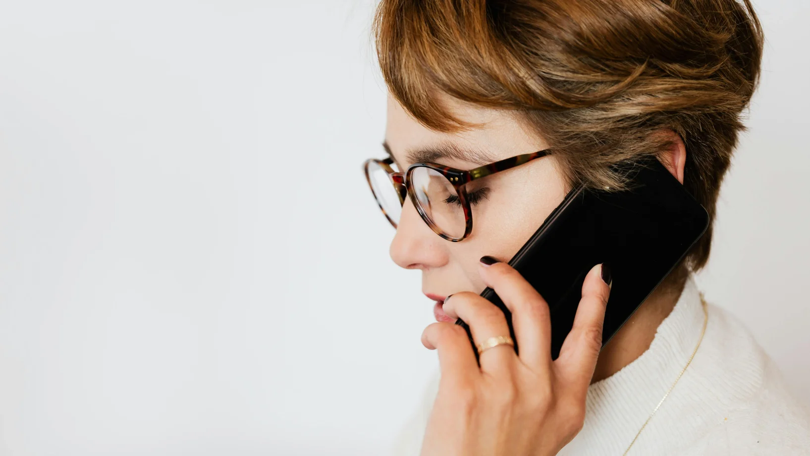 Thoughtful adult woman talking on smartphone