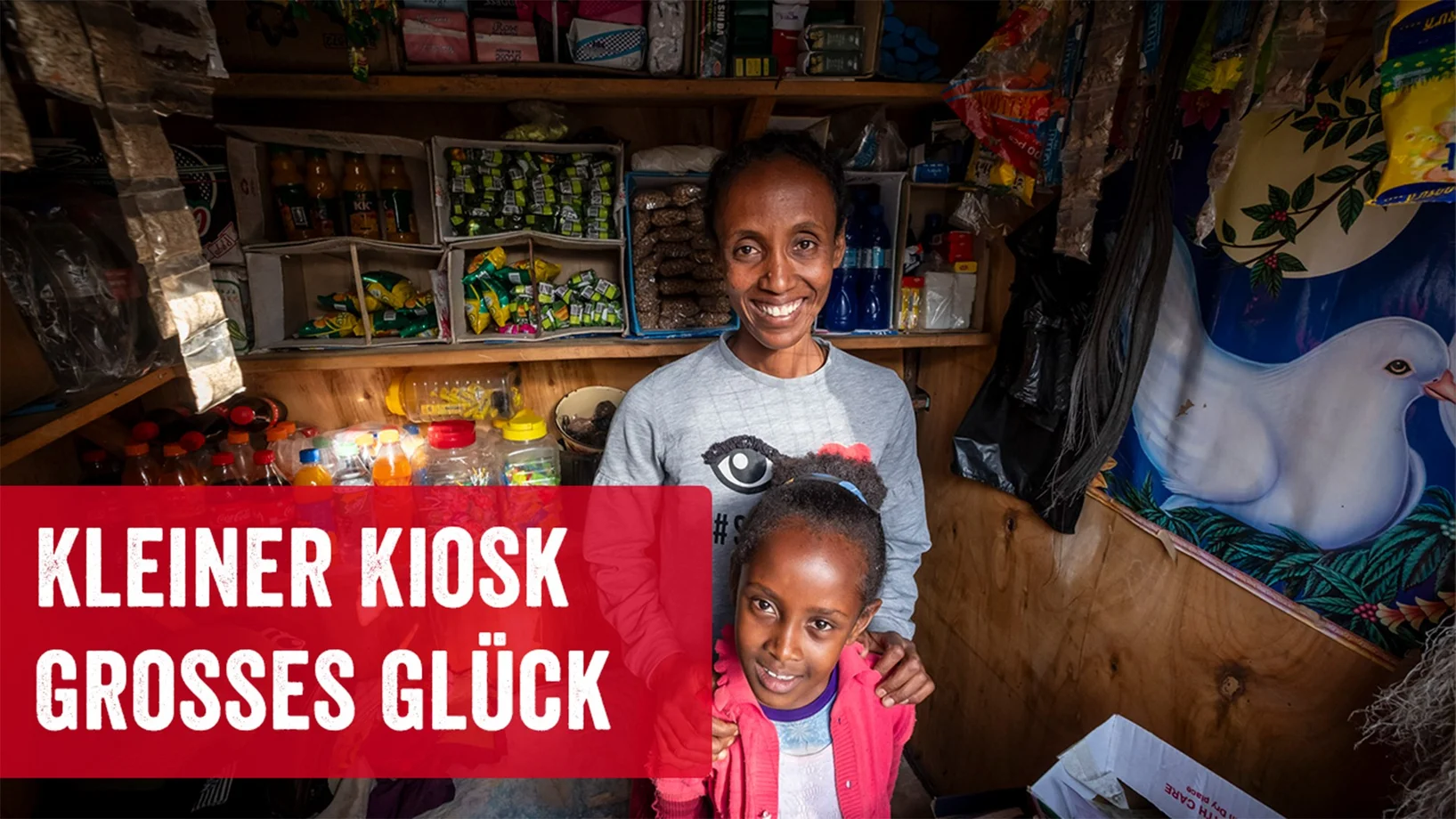 Kioskbesitzerin Yeshi mit Tochter und Schriftzug "Kleiner Kiosk grosses Glück"