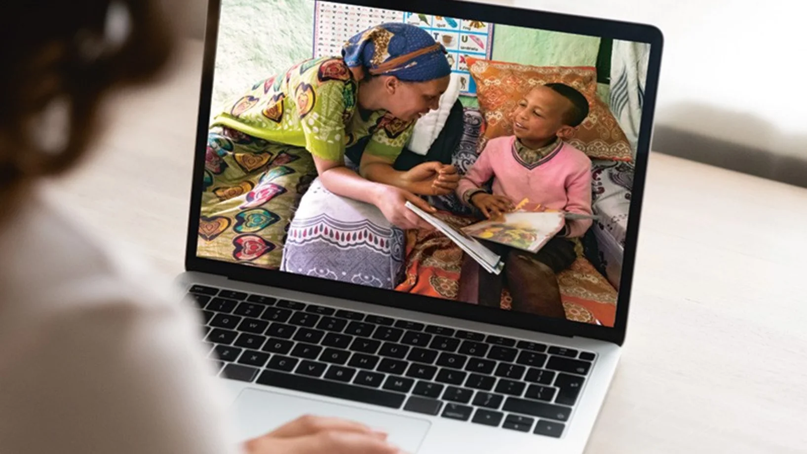 Notebook-Bildschirm mit Mutter, die ihren Sohn bei der Hausarbeit unterstützt