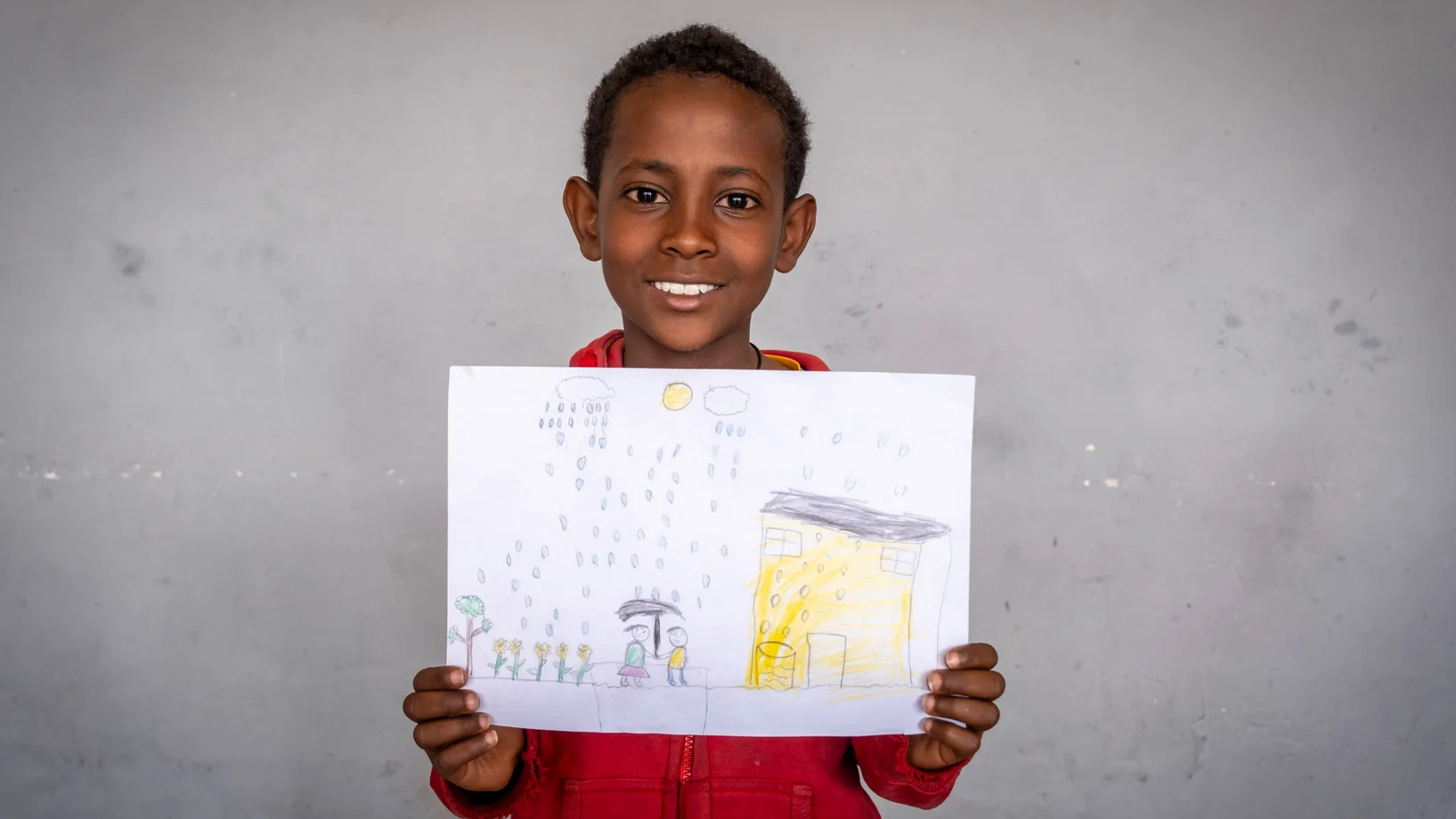 Junge zeigt stolz seine Zeichnung