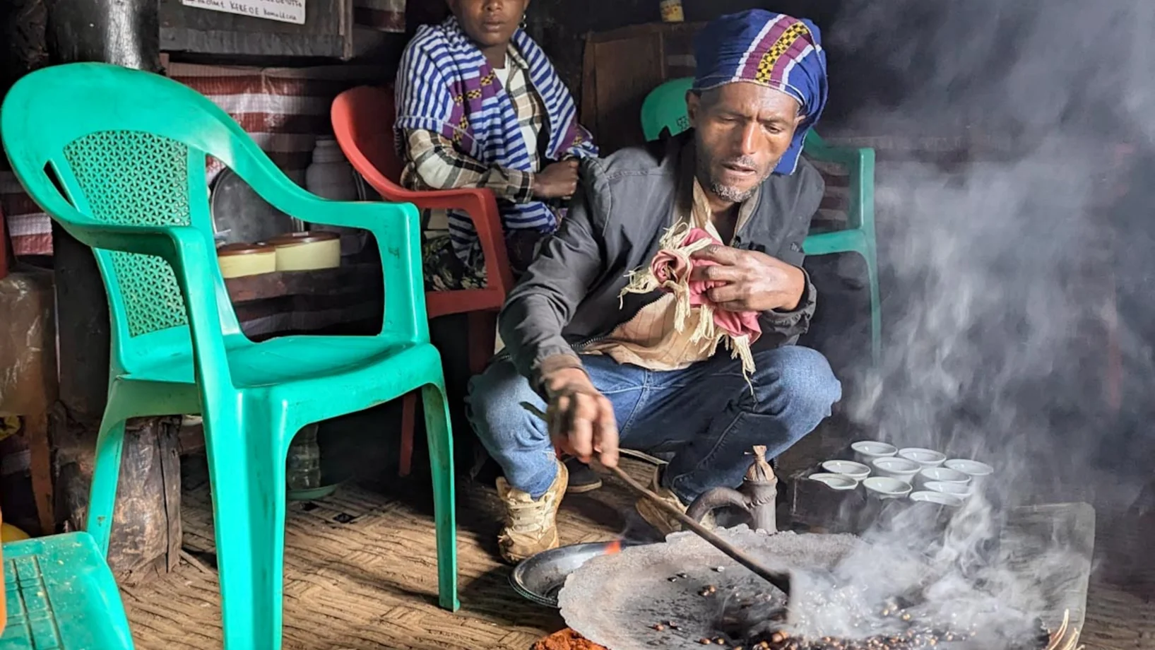Bauer röstet Kaffee vor den Augen seiner Frau