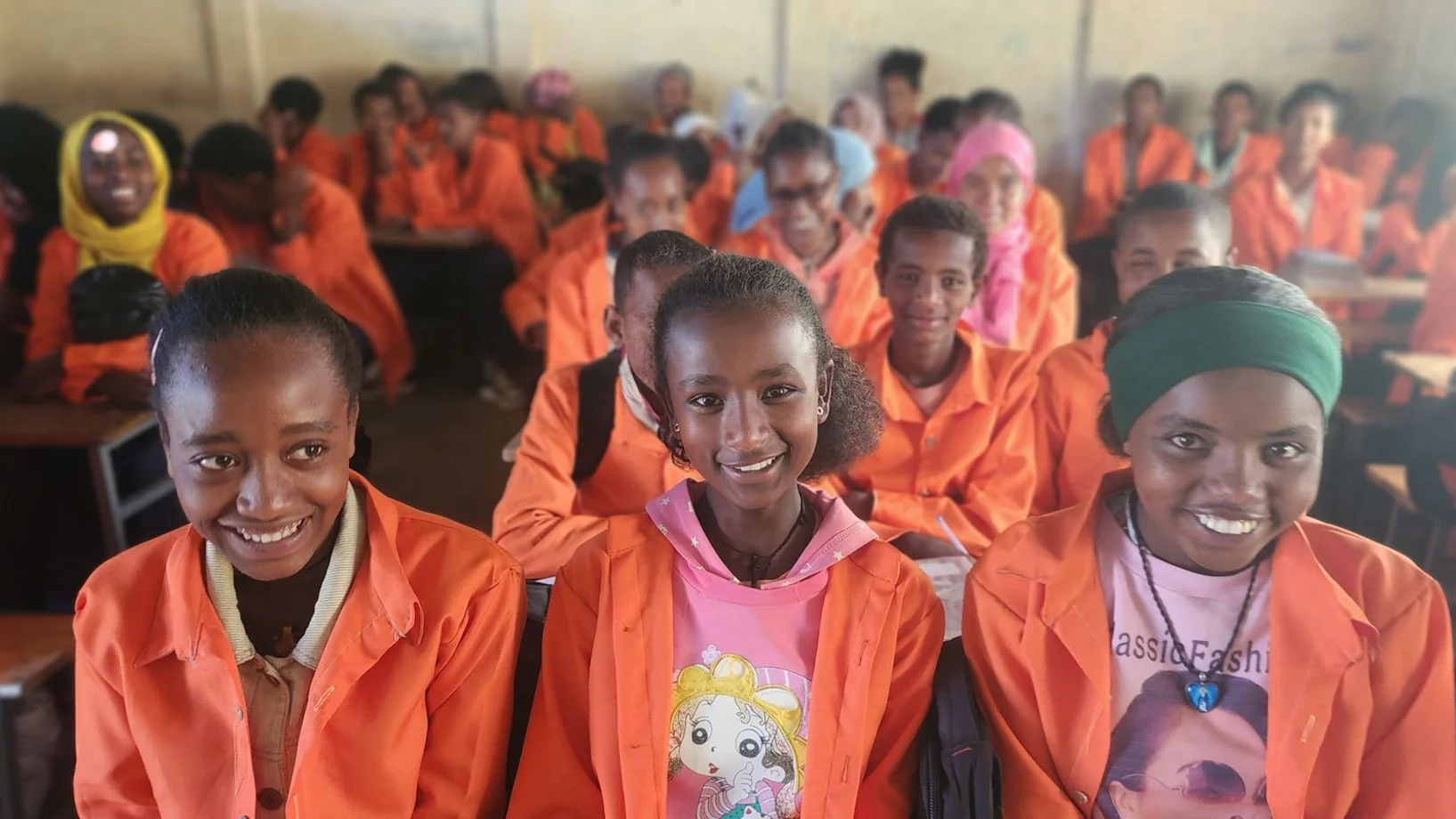 Schülerinnen in orangen Schuluniformen